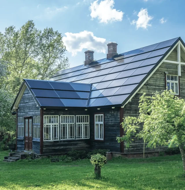 Historic dark wooden house with an integrated solar roof.