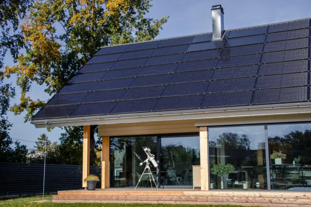 Home with an integrated solar roof and a telescope on the terrace.