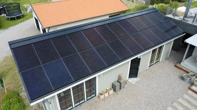 Aerial view of an integrated solar roof on a residential outbuilding.