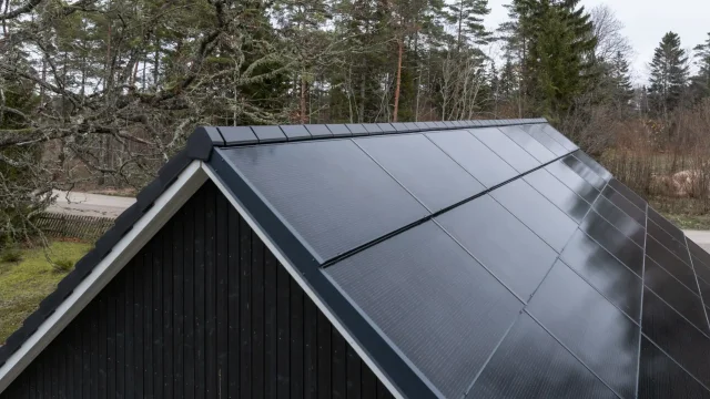 Integrated solar roof with matching flat roof tiles along the ridge and edges.