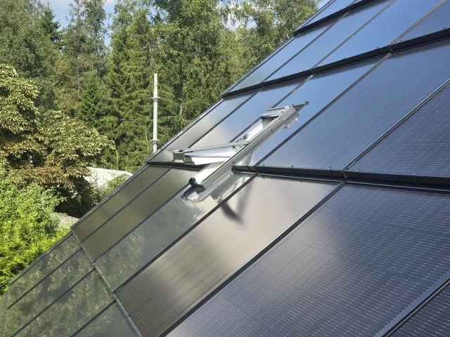 Close-up of a roof window integrated into a full solar roof.