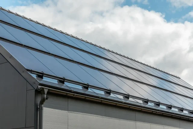 Close-up of an integrated solar roof fitted with snow guards and guttering.
