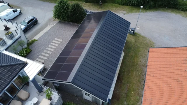 Aerial view of an integrated solar roof combined with standing-seam metal roofing in Sweden.