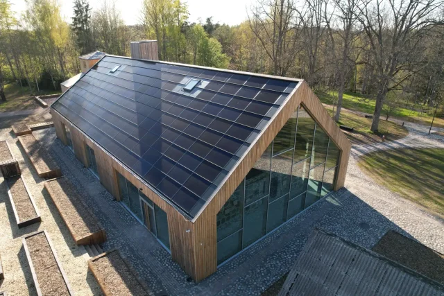 Aerial view of a modern timber building with a full integrated solar roof.