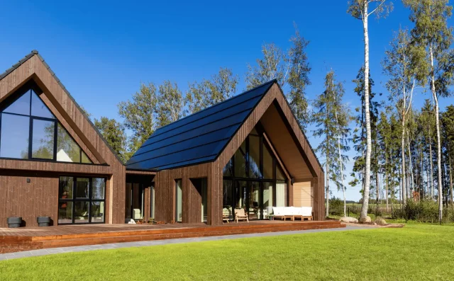 Modern timber home with an integrated solar roof on a sunny summer day.