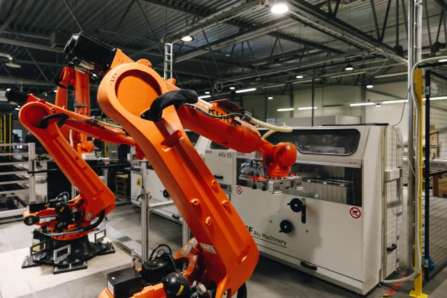 Multiple industrial robots inside an automated metalworking production cell.