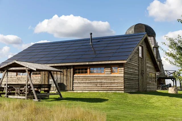 Rustic wooden building with a full integrated solar roof.