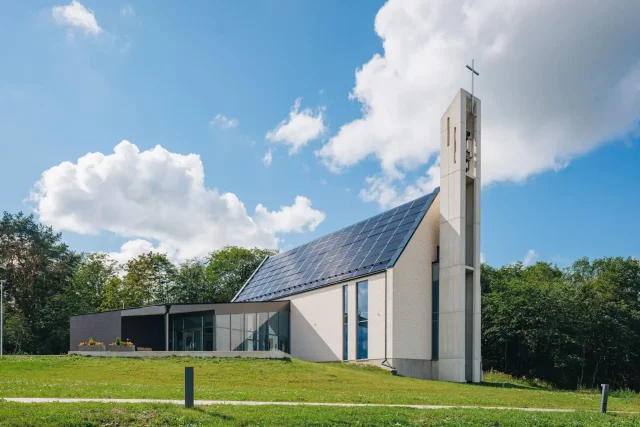 Saku Church with an integrated solar roof under a blue sky.
