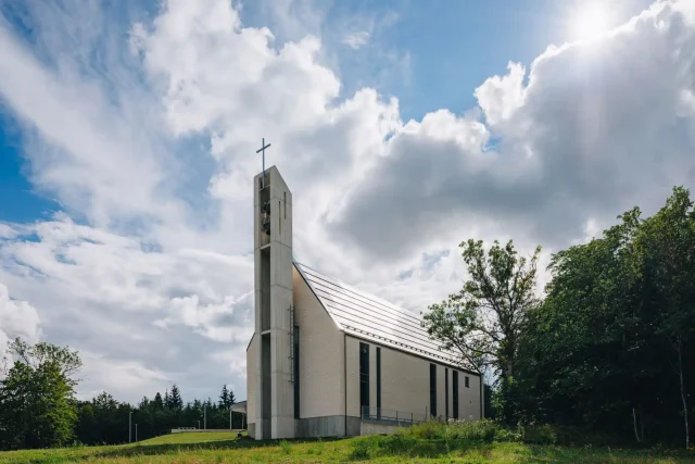 Side view of Saku Church with an integrated solar roof and bell tower.