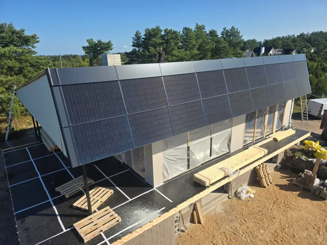 Elevated side view of a Solar Full Roof™ installation on a modern building under construction.