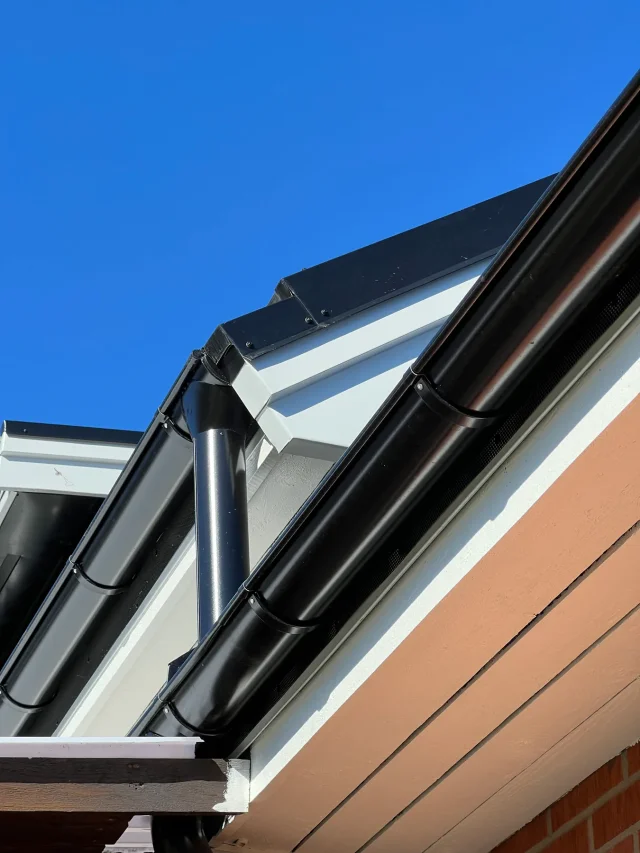 Finished Solar Full Roof™ eave and downpipe detail on a red-brick home.