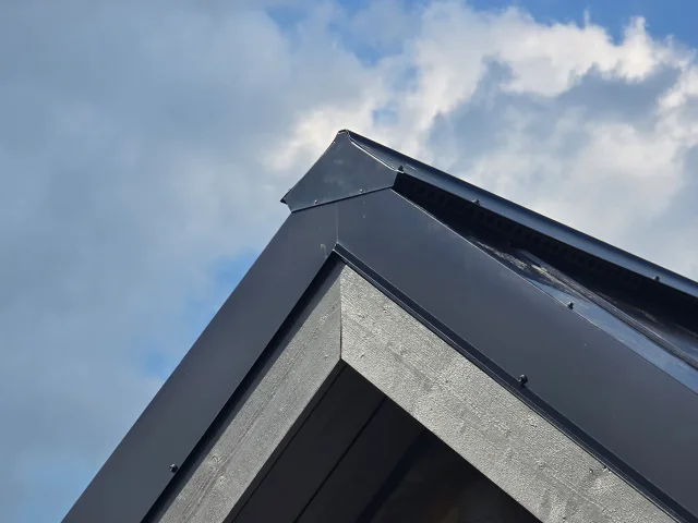 Low-angle close-up of black eave flashing beneath a Solar Full Roof™ installation.