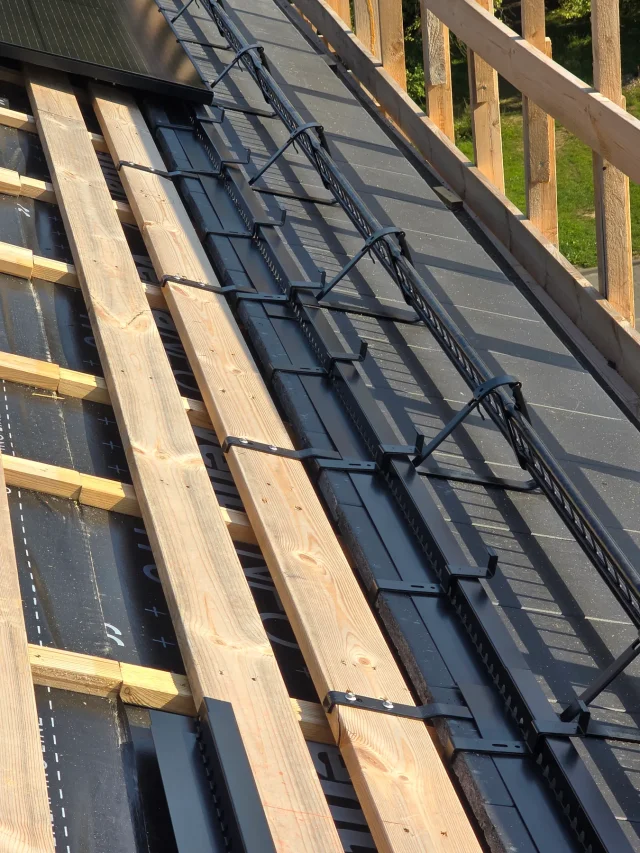 Close-up of Solar Full Roof™ edge mounting components beside wooden roof battens.