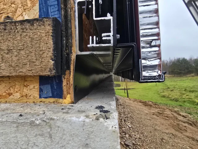 Close-up of a Solar Full Roof™ edge profile beside wall insulation and metal cladding.