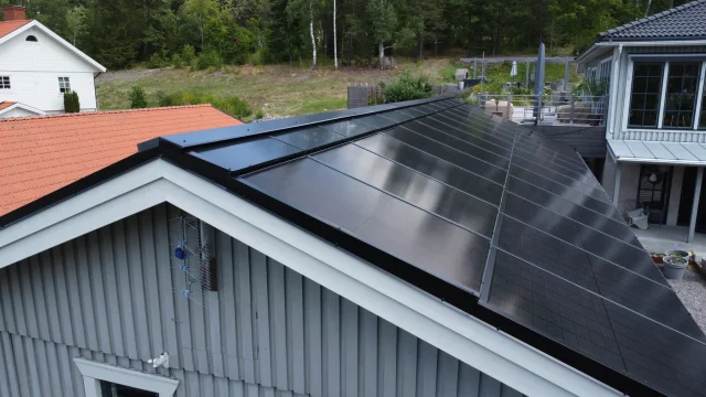 Aerial view of a grey wooden home with a completed Solar Full Roof™ installation.