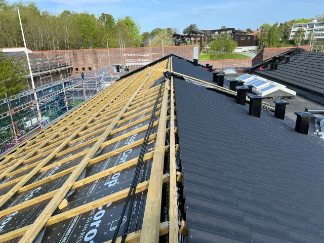 Large roof with Solar Full Roof™ modules installed beside exposed timber battens.