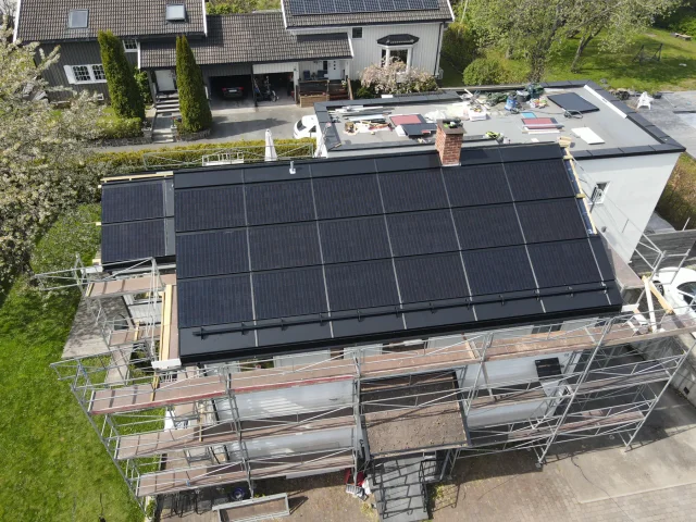 Aerial side view of a large building with Solar Full Roof™ modules covering the pitched roof.