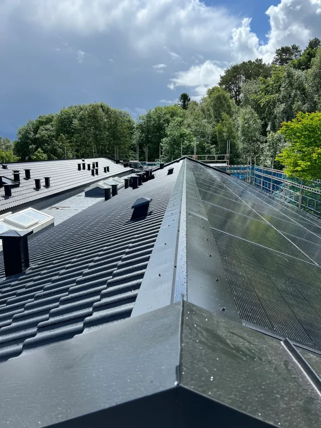 Long scaffolded roof with Solar Full Roof™ modules and multiple roof penetrations.