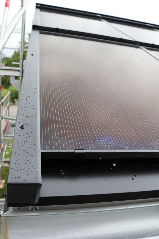 Close-up of a Solar Full Roof™ module edge above the gutter and roof battens.