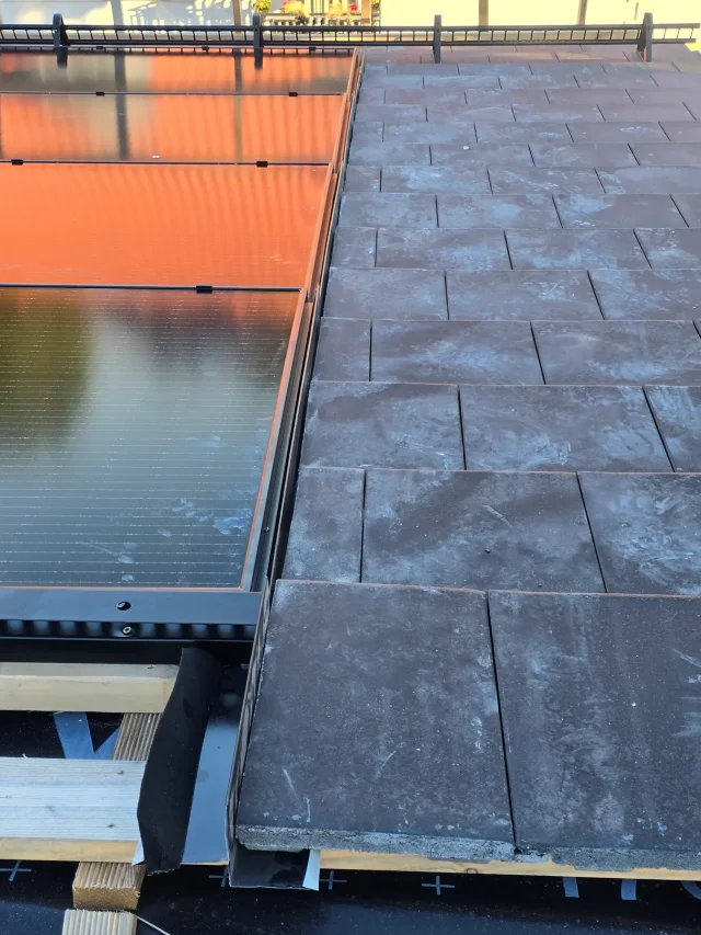 Close-up of the transition between Solar Full Roof™ modules and grey roof tiles.