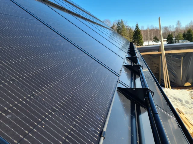 Close-up of the mounting rail and clamps along a row of Solar Full Roof™ modules.