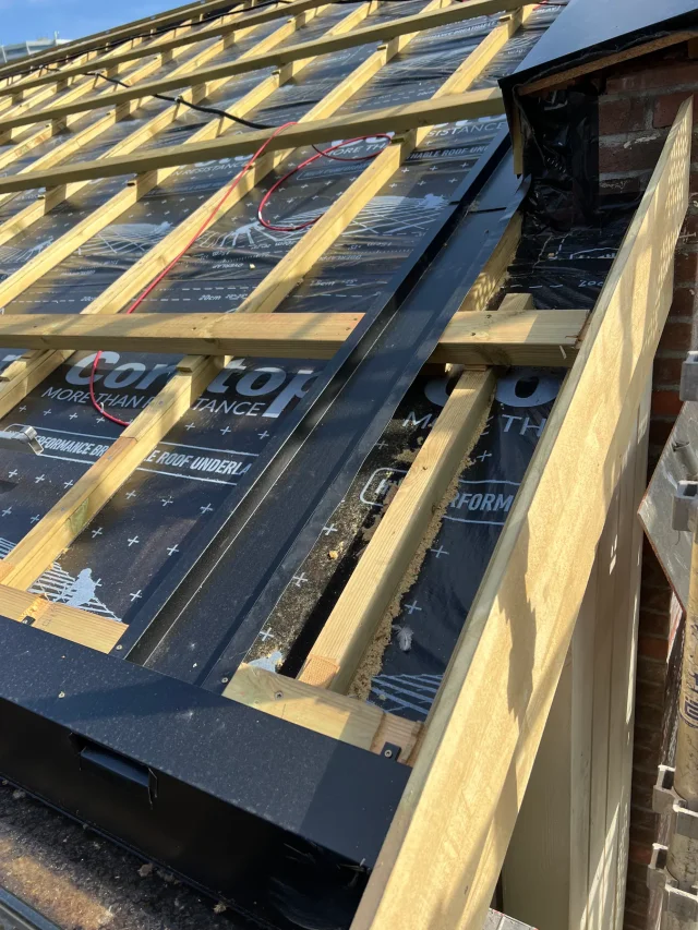 Black parapet gutter installed along roof battens and underlay for a Solar Full Roof™ system.
