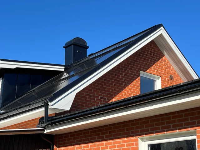 Red-brick home with a Solar Full Roof™ installation, chimney and rain gutter.