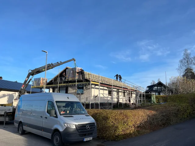 Street view of a residential Solar Full Roof™ installation with scaffolding and a service van.