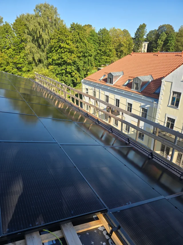 Completed Solar Full Roof™ installation overlooking a riverside town.
