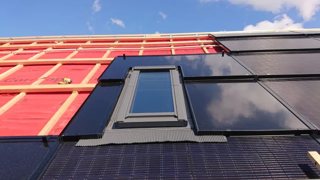 Solar Full Roof™ modules and flashing being installed around a roof window.