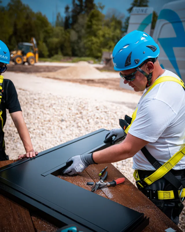 Installer fitting a U-profile along the edge of a Solar Full Roof™ module.