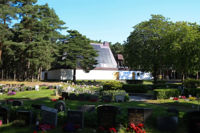 Chapel with a Solar Tiled Roof™ installation beside a tree-lined cemetery.