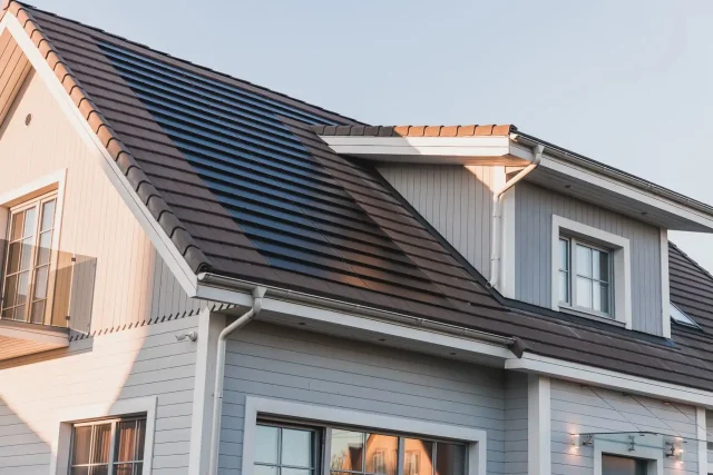 Solar Tiled Roof™ installation integrated into the tiled roof of a grey wooden home.
