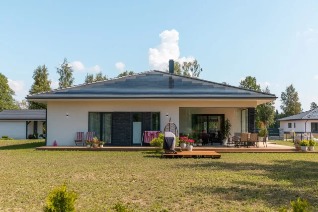 Modern bungalow with a Solar Tiled Roof™ installation and furnished garden terrace.