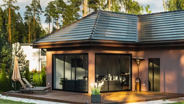 Modern home with a Solar Tiled Roof™ installation and garden terrace in evening light.