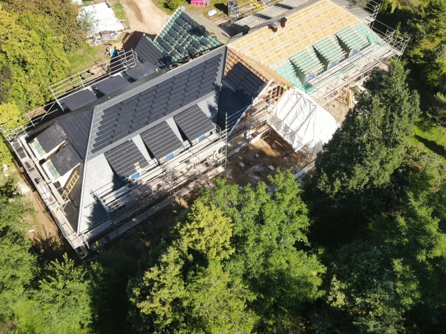 Aerial side view of Solar Tiled Roof™ modules installed across several roof sections.