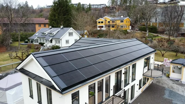 Aerial view of a white building with a full integrated solar roof.